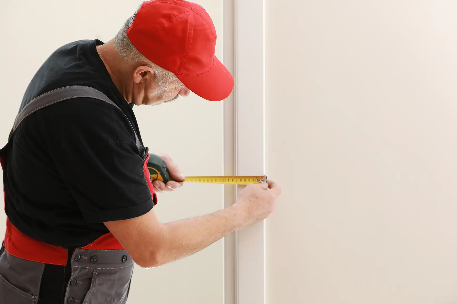 Handwerker misst Türzarge für den Einbau einer Innentür